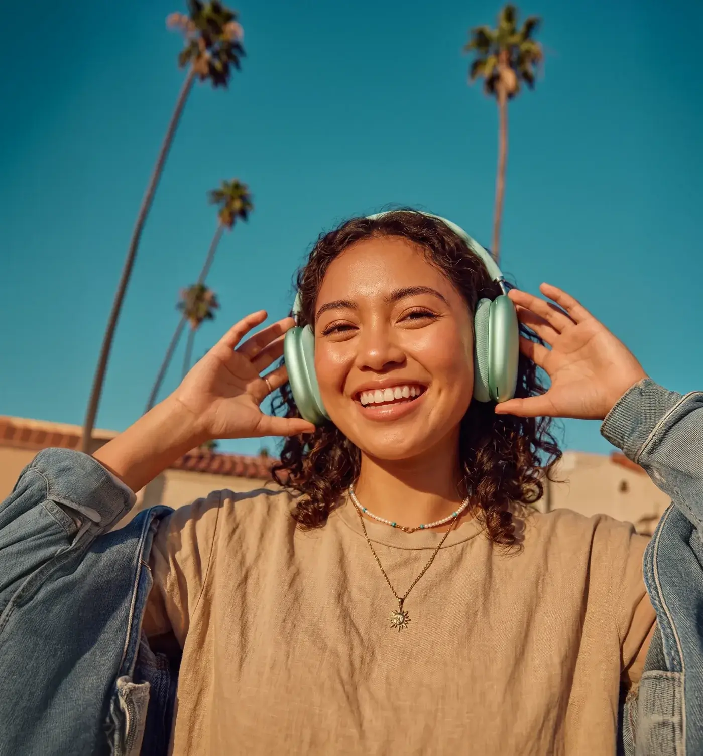 Smiling woman wearing headphones, framed inside the Laserly spark shape